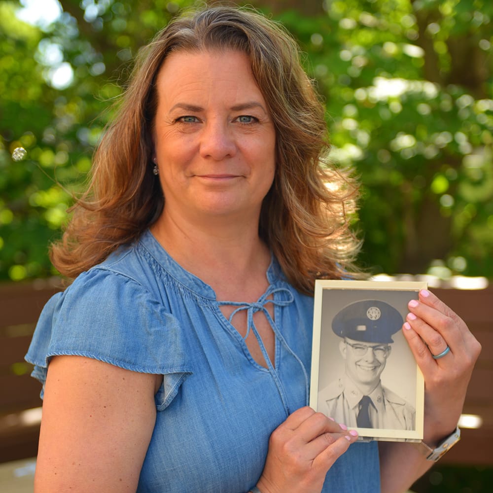 Michelle Wickum holding a photo of her father in his military uniform.