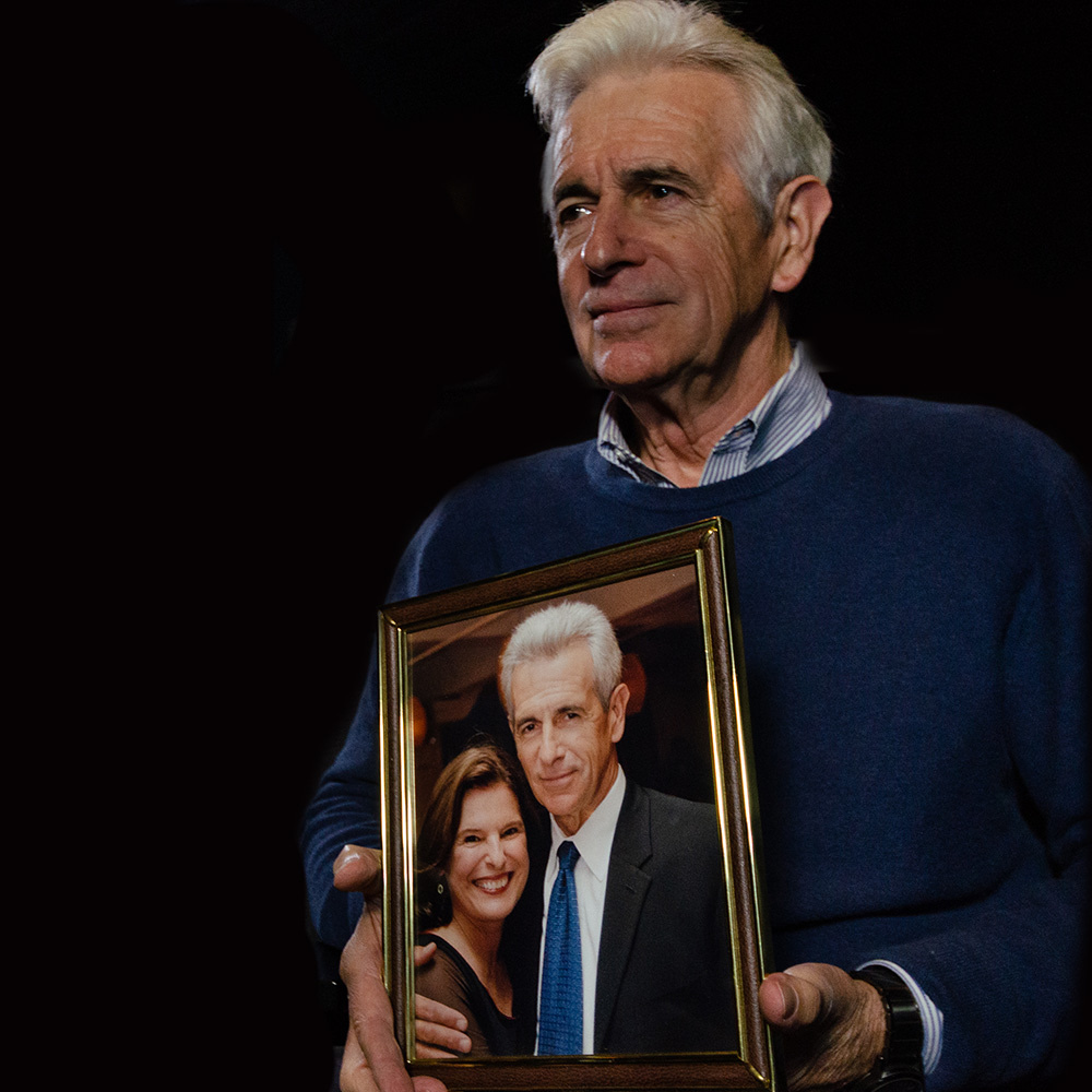 Actor James Naughton holding a photo of he and his wife Pam