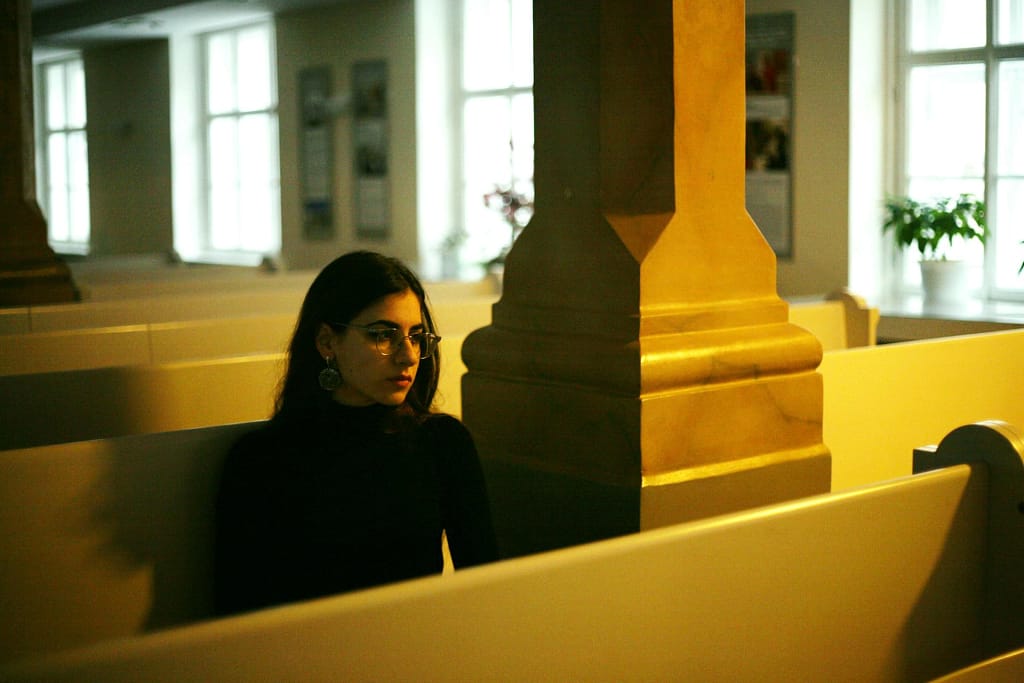 young woman seated in a pew