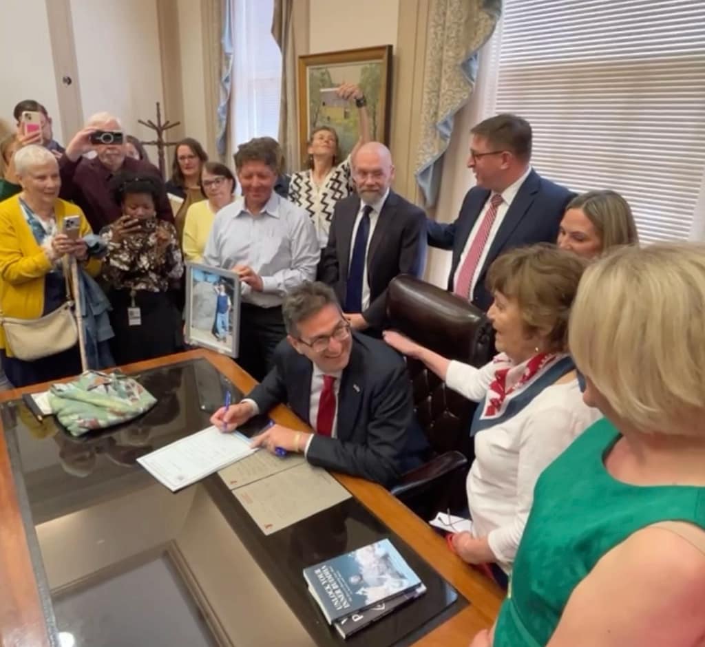 Governor Meyer signs the Ron Silverio/Heather Block Delaware End-of-Life Options Act into law surrounded by advocates and legislative champions on May 20.