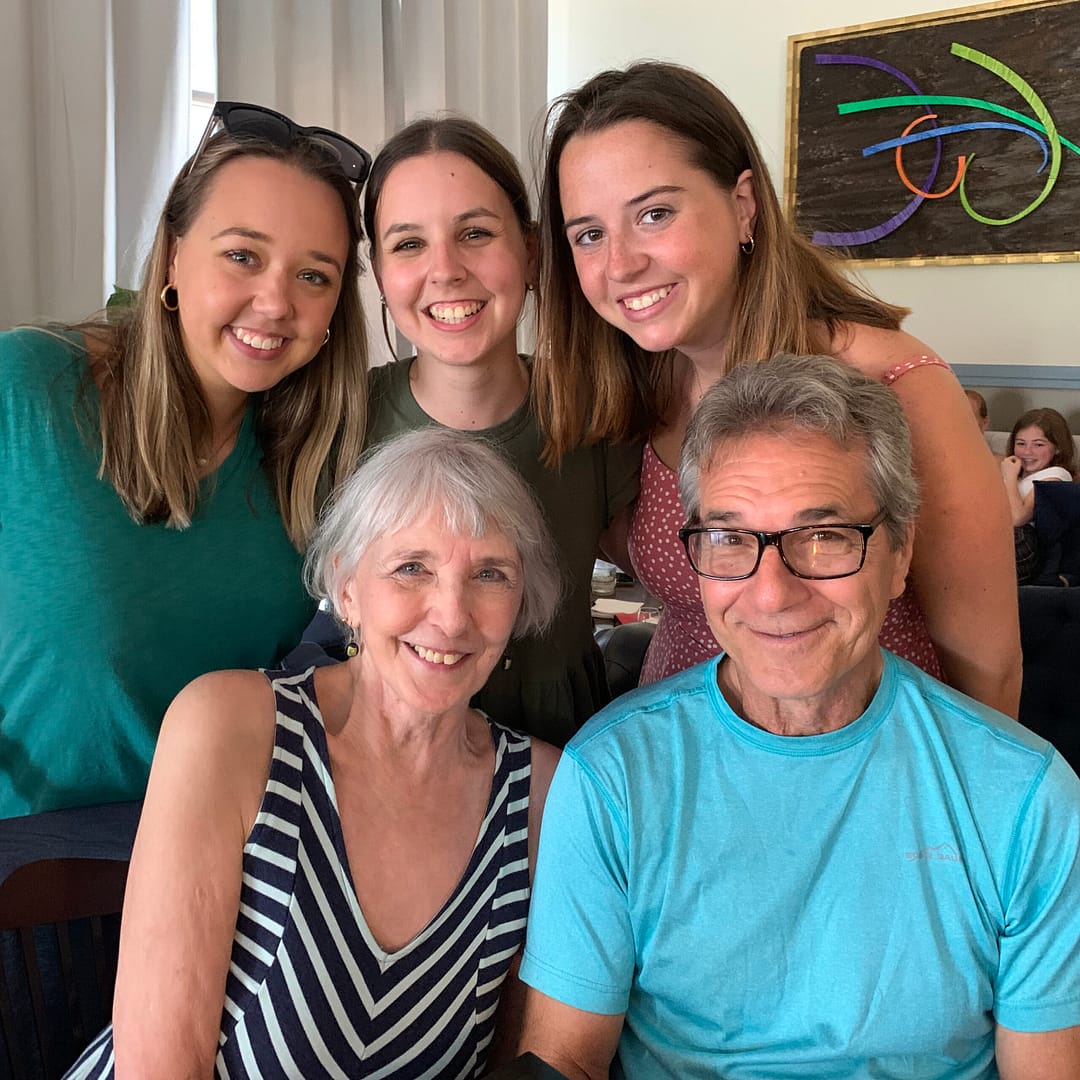 Janina and Gary Birtolo seated in a restaurant surrounded by three granddaughters.