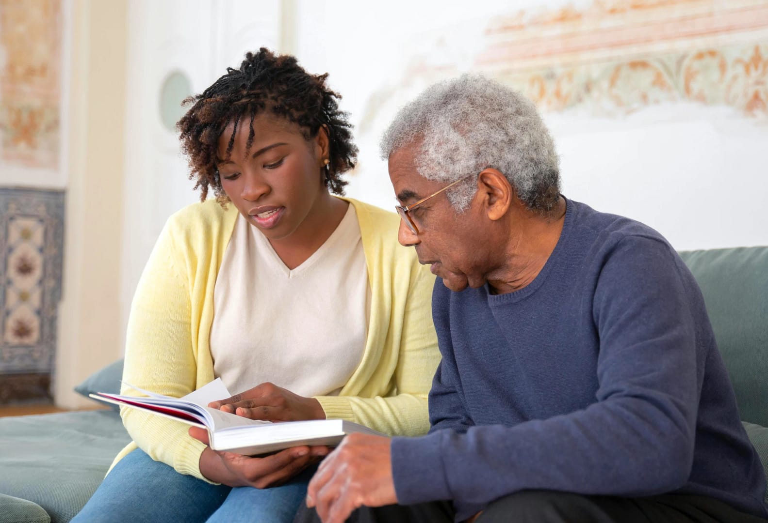 A young African-American woman works through an estate planning book with her father