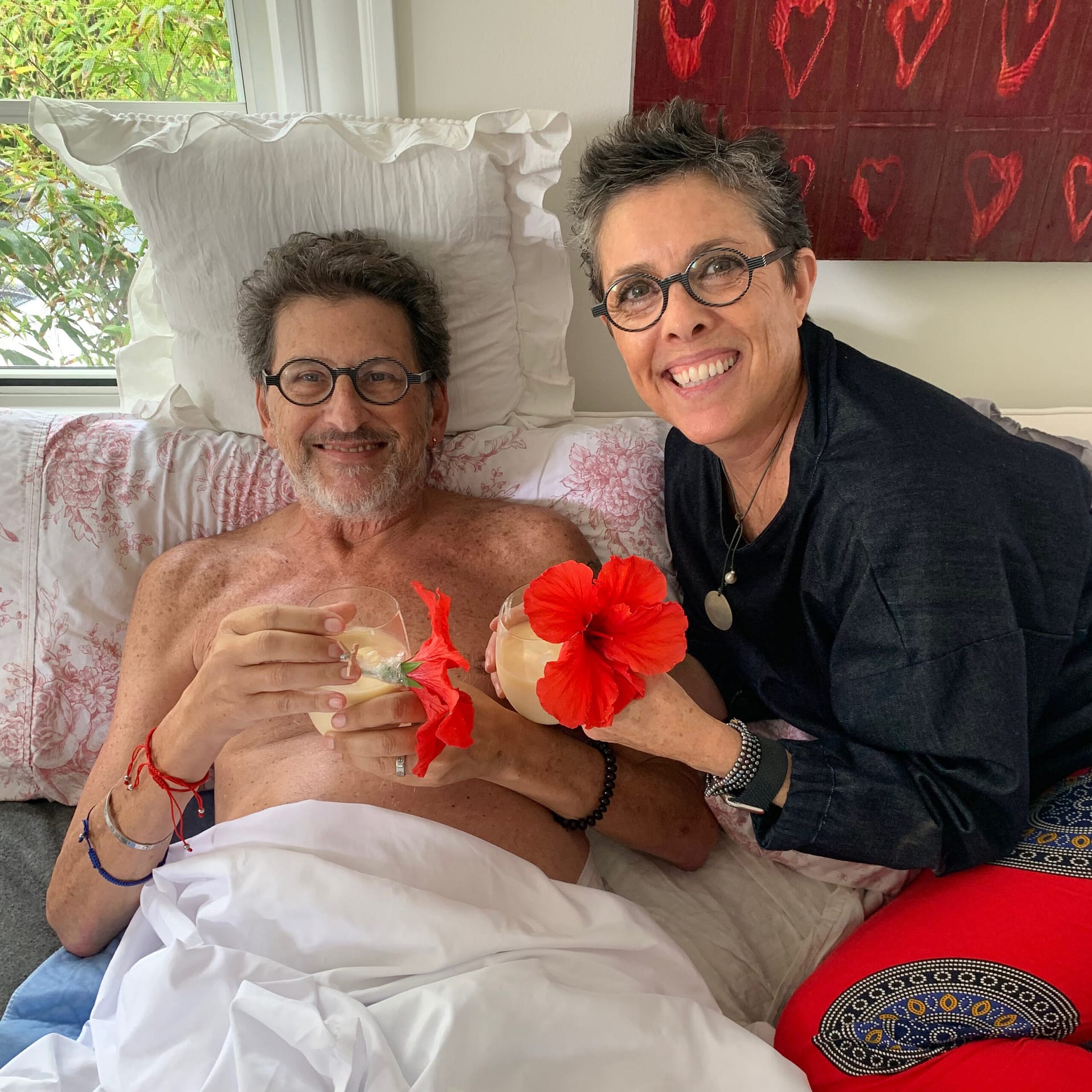 Alison Clay Duboff and her Husband Ken Duboff in a hospital bed with tropical drinks