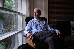 Dr. Nick Gideonse sits in front of a window and looks out of it solemnly