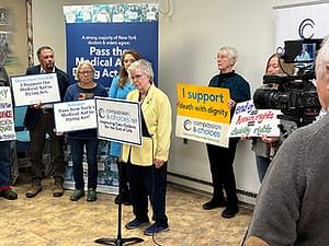 New York Citizens Holding Signs urging legislatures to pass medical aid in dying