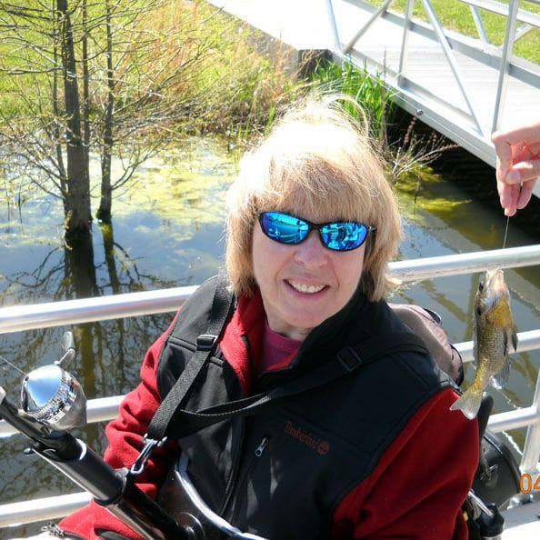 Vickie George with a fishing pole and a recently caught Fish