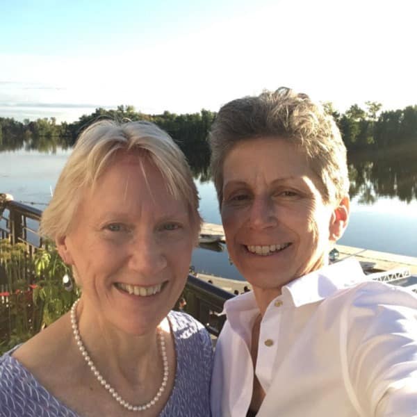 Joy Cipollo and wife Kim Hoffman take a photo in front of a river