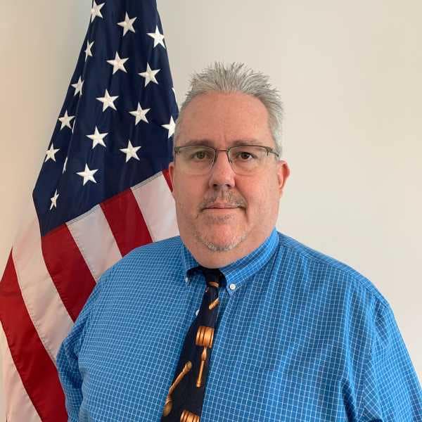 Leo Bulavko standing in front of American Flag