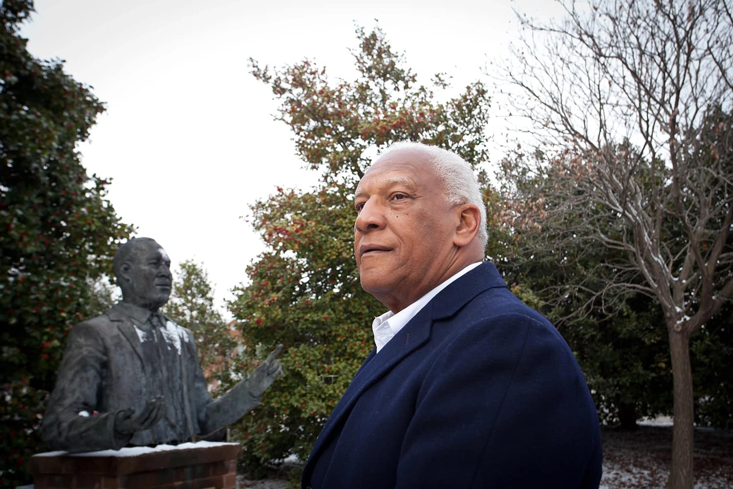 Aris Allen looking at his father's statue