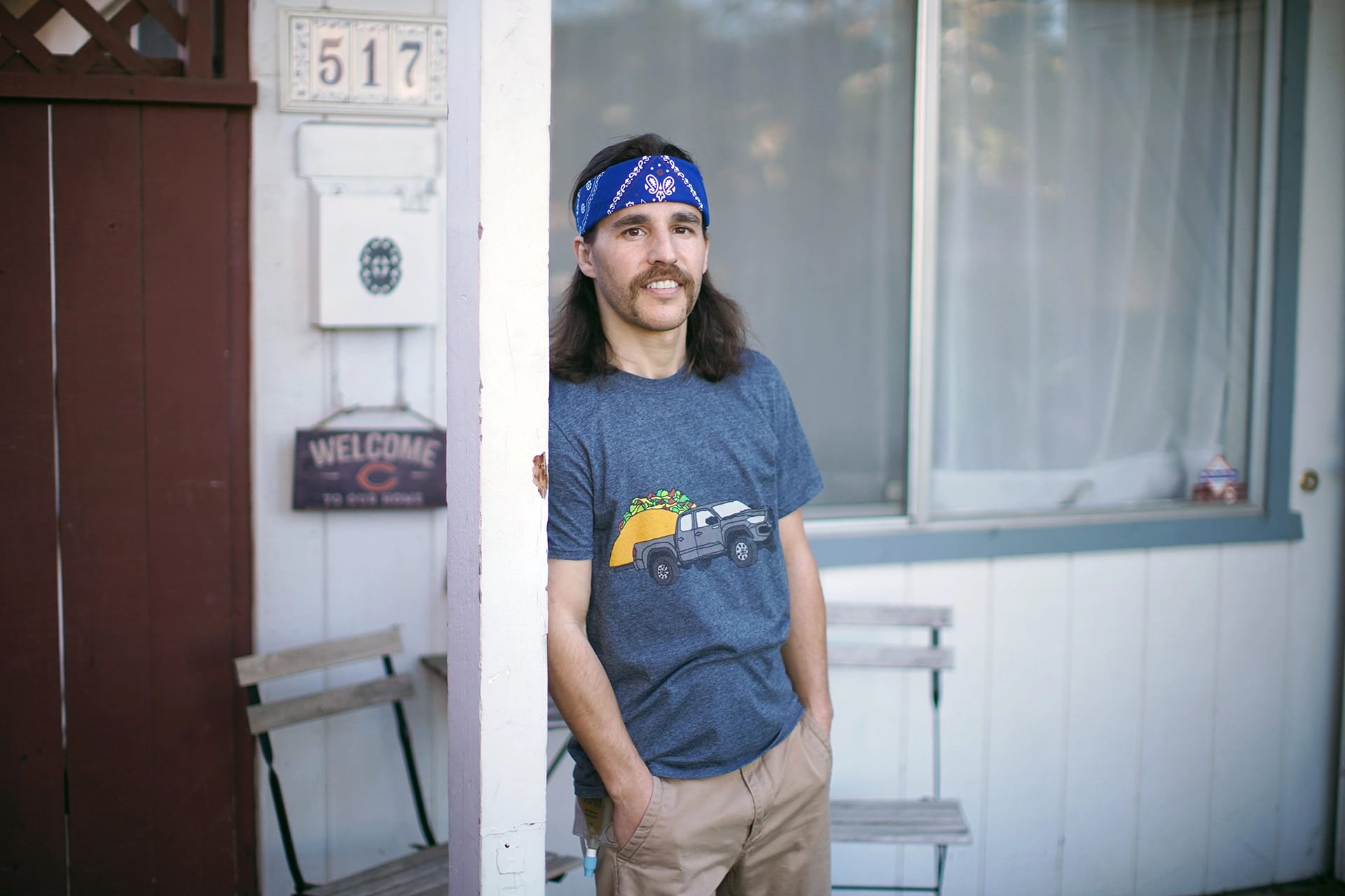 Andrew Flack standing on his front porch smiling.