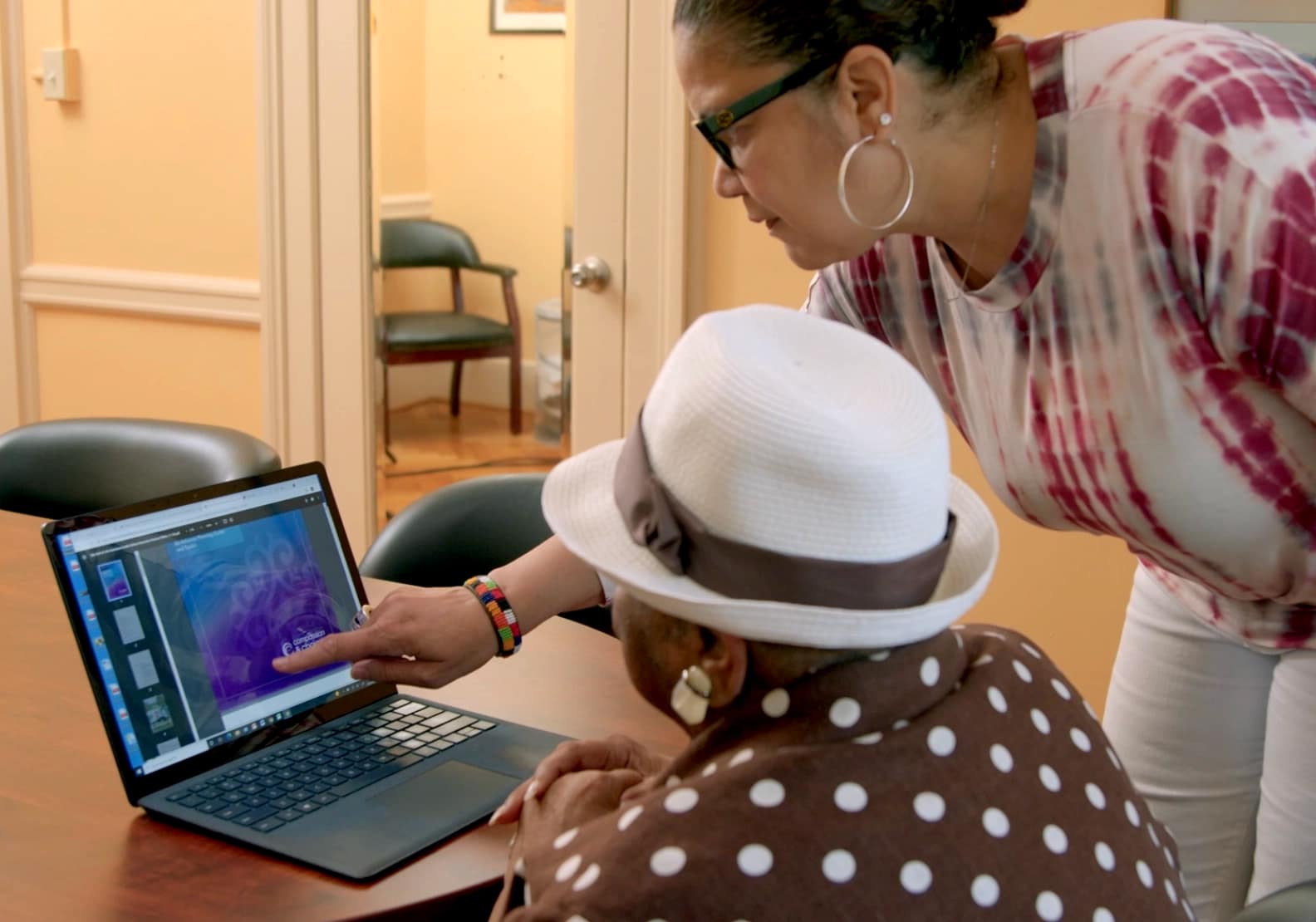 A woman helps another person navigate the End of Life Decisions Guide on a computer screen